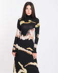 Model wearing long-sleeved dress with original NANICHE print made of visoze flowing material.